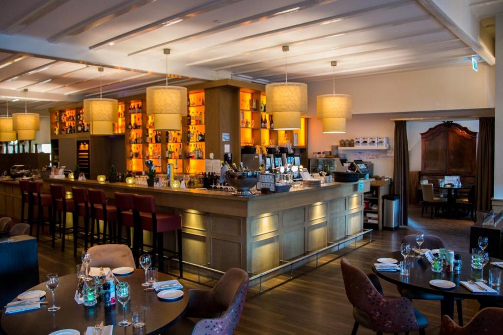 维里Hotel Veere的一间带桌椅的餐厅和一间酒吧