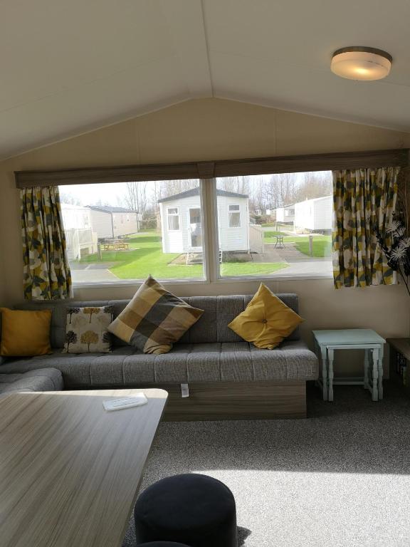 Flookburghlakeland leisure park的带沙发和大窗户的客厅