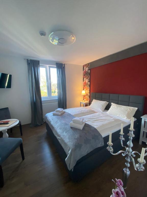 Hasenmoor德尔坦扎瑟宾馆的一间卧室设有一张红色墙壁的大床