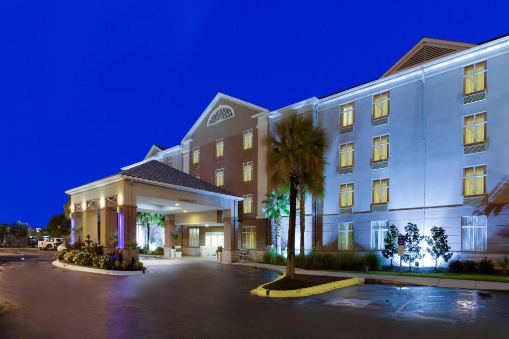 查尔斯顿查尔斯顿阿什利法斯菲特智选假日套房酒店的一座建筑前有棕榈树的酒店