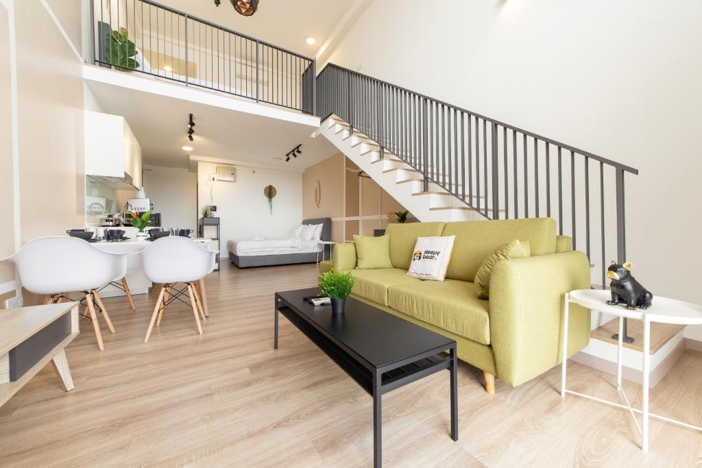 八打灵再也Emporis Service Apartment By Sleepy Bear的客厅设有黄色沙发和楼梯。