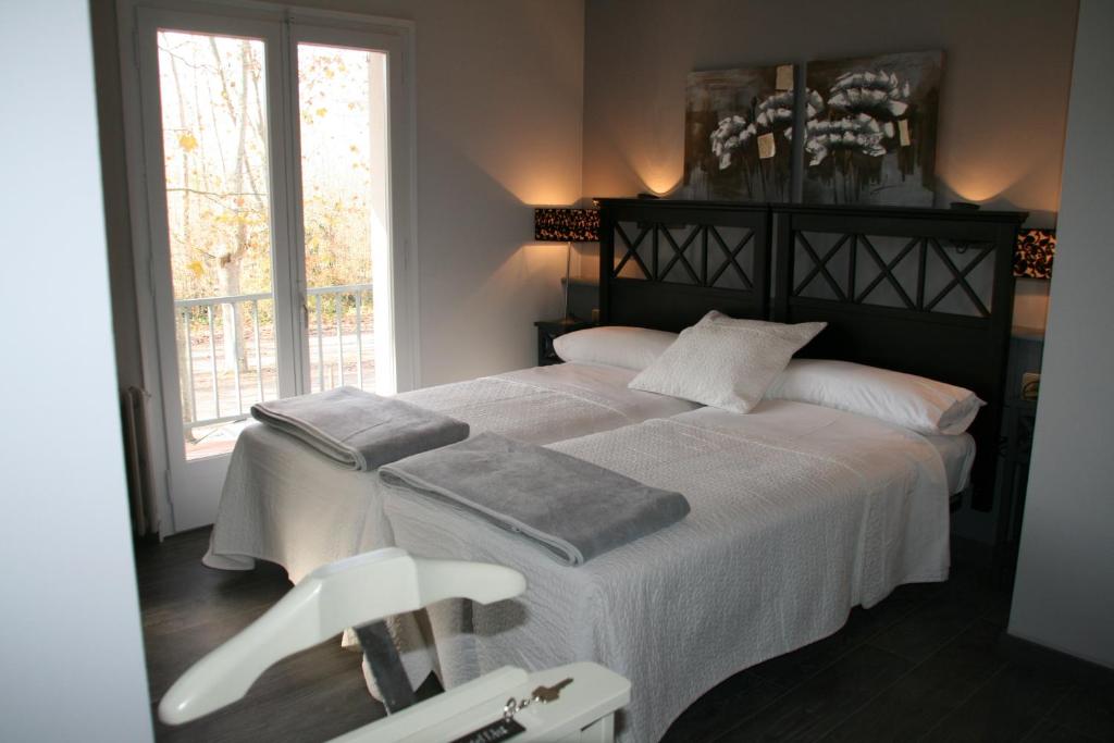 班约莱斯阿斯特酒店的一间卧室配有一张大床和两条毛巾
