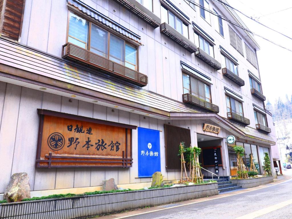 十日町Nomoto Ryokan Matsunoyama Onsen的建筑的侧面有标志