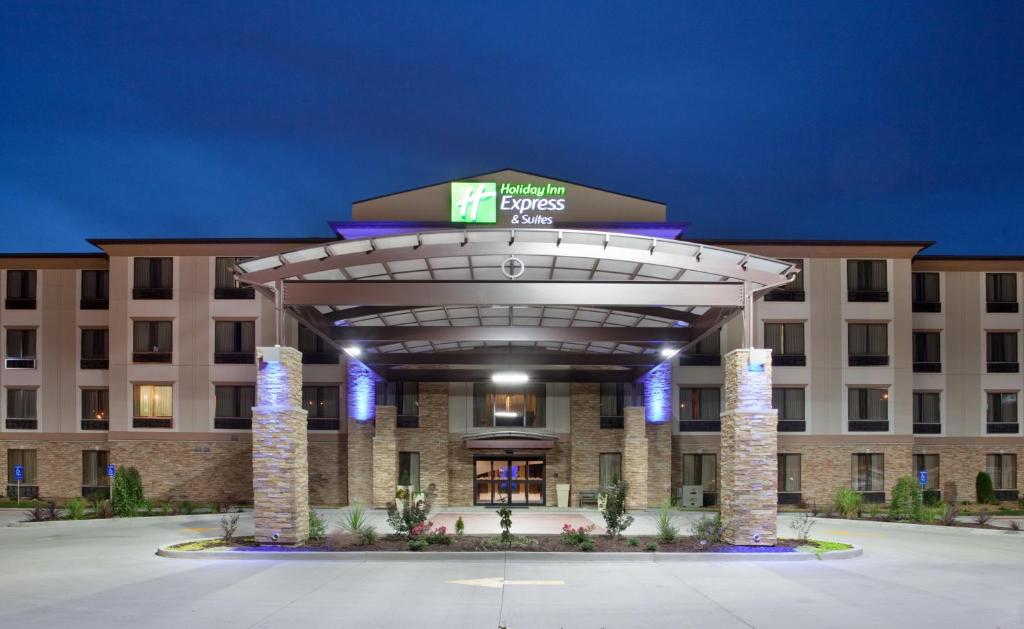 伍德森特瑞斯Holiday Inn Express & Suites St Louis Airport, an IHG Hotel的一家酒店,晚上有一座大建筑