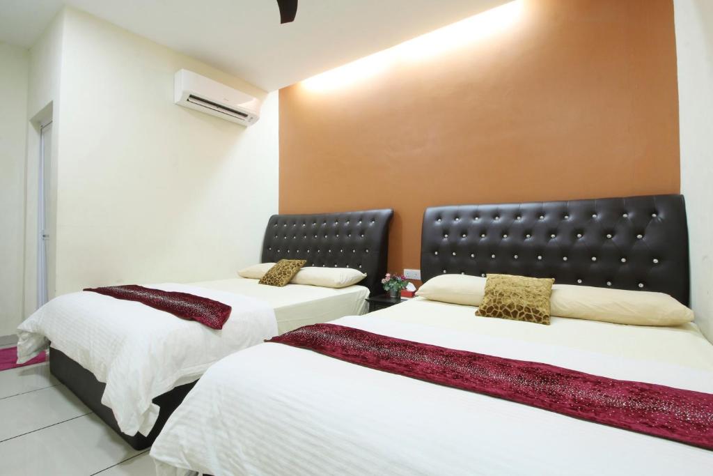 莎阿南莎阿南智慧城市米米拉拉酒店的两张睡床彼此相邻,位于一个房间里