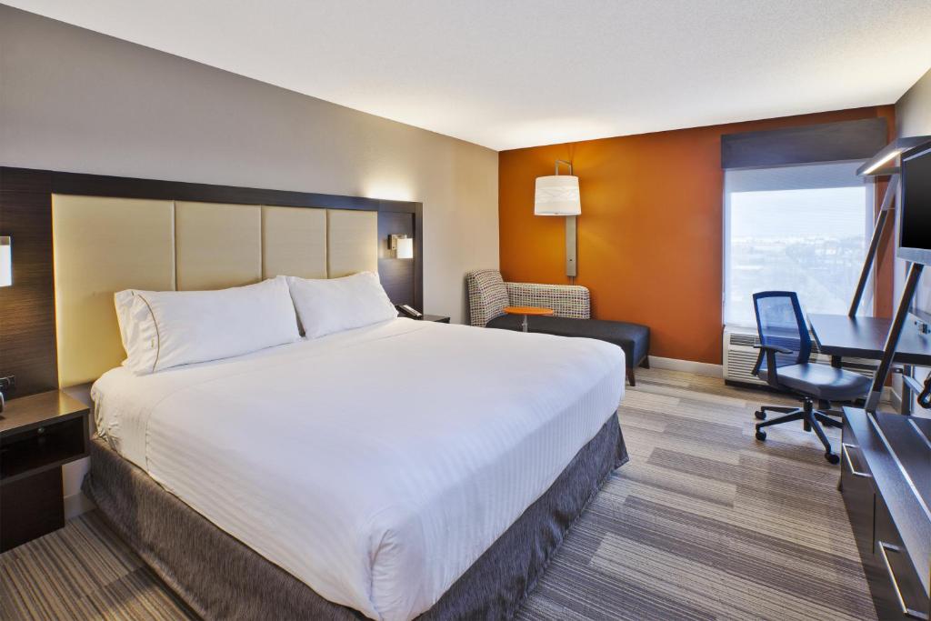 贝德福德公园Holiday Inn Express & Suites Chicago-Midway Airport, an IHG Hotel的酒店客房设有一张大床和一张书桌。