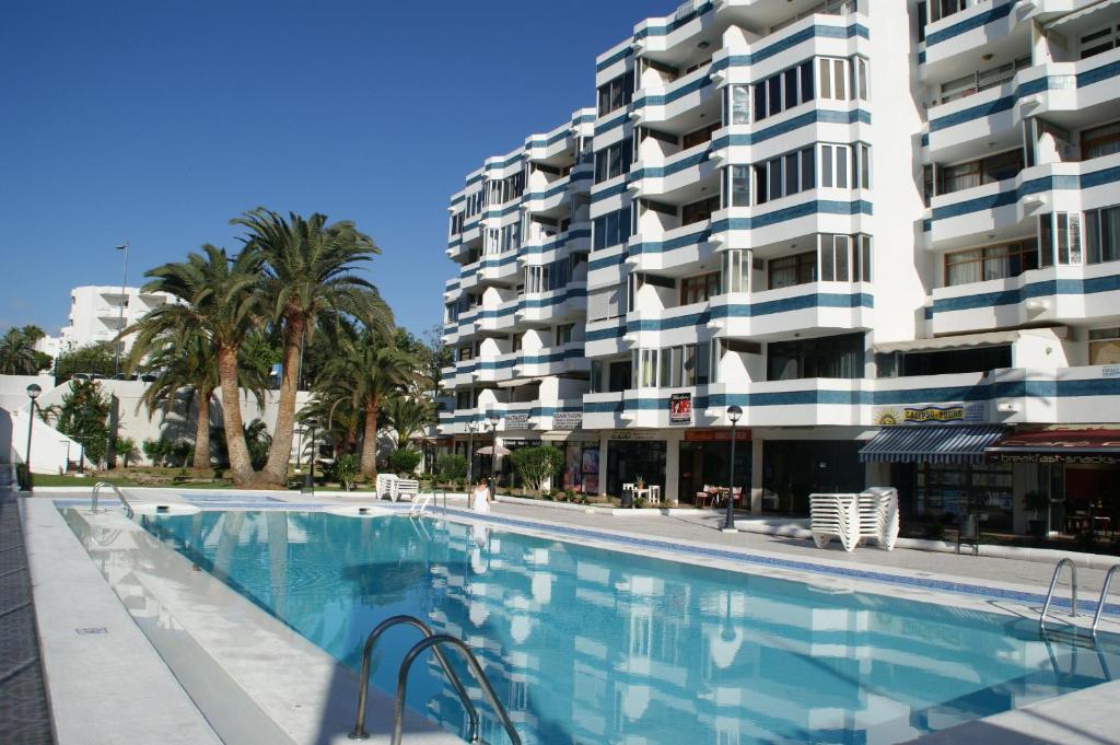 英格兰海滩Apartamentos Teror - Gavias del Sol的大楼前的游泳池