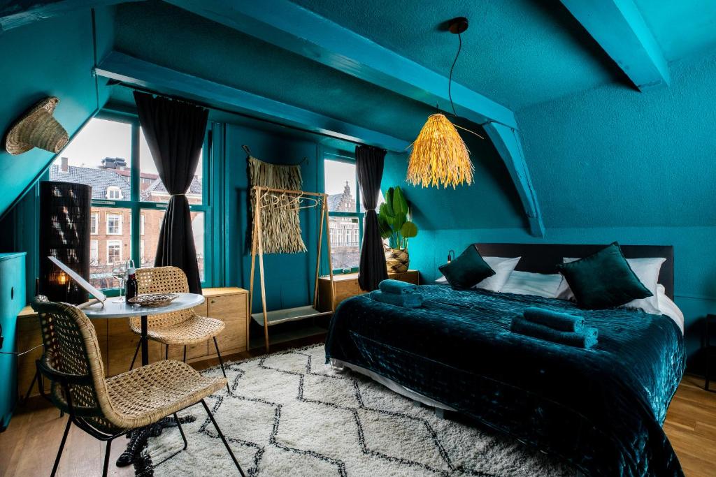 哈莱姆Bambu Sleep Boutique的蓝色卧室配有床、桌子和椅子