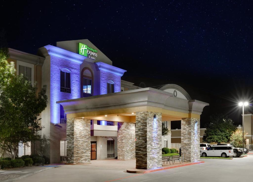 邓肯维尔Holiday Inn Express & Suites Dallas - Duncanville, an IHG Hotel的夜间有蓝色灯光的建筑的酒店