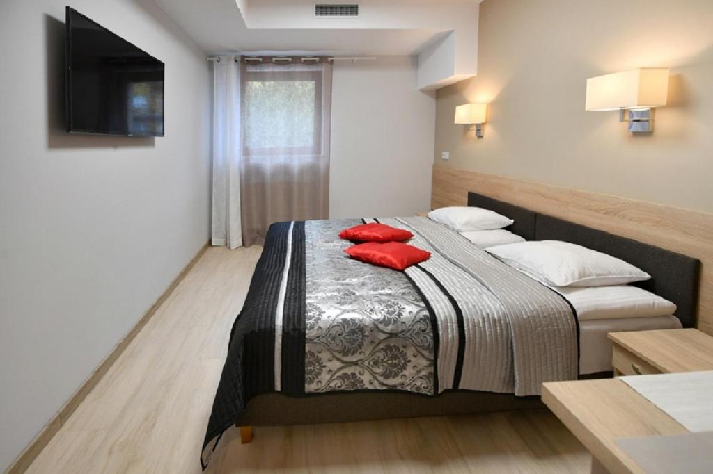 宗布基弗特克斯酒店的一间卧室配有一张带红色枕头的床