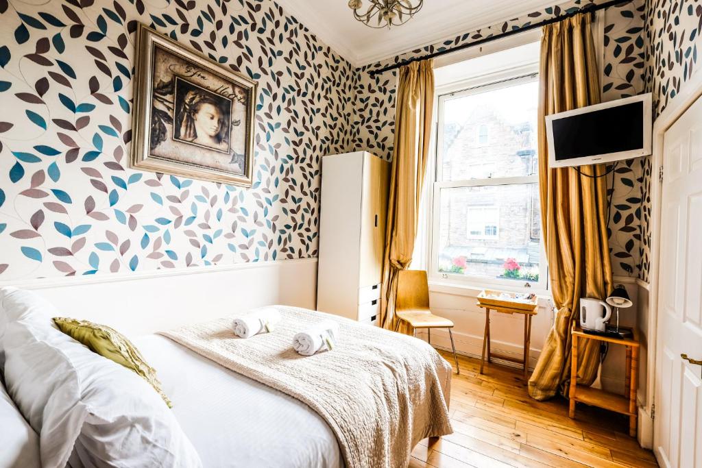 爱丁堡巴尔莫尔宾馆的一间卧室配有床和壁纸覆盖的墙壁