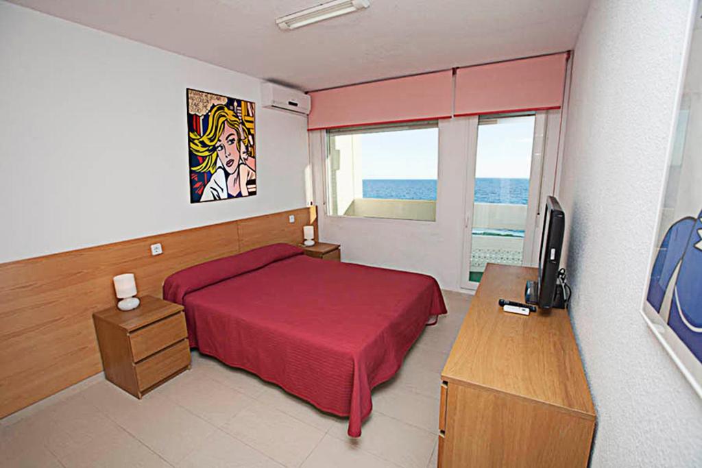 马塔拉斯卡尼亚斯Apartamento con vistas al mar primera linea playa Matalascañas的一间卧室配有一张床、一张书桌和一台电视