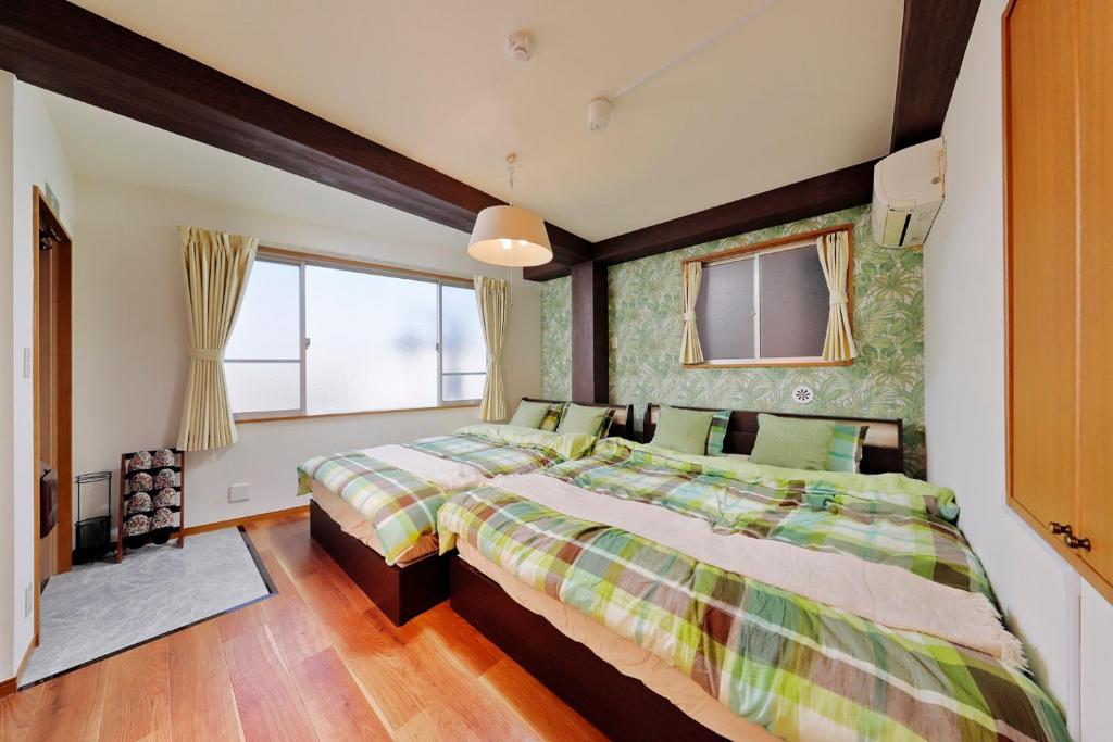 东京Terrace Terano#201的一间卧室设有两张床和窗户。