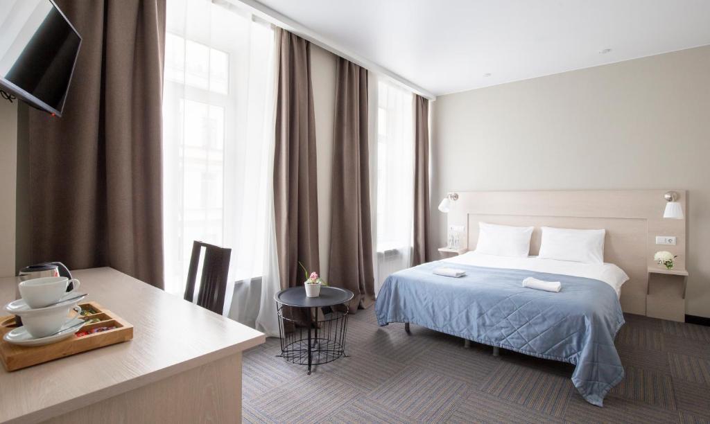 圣彼得堡涅夫斯基紫苑酒店的酒店客房设有床、桌子和窗户。