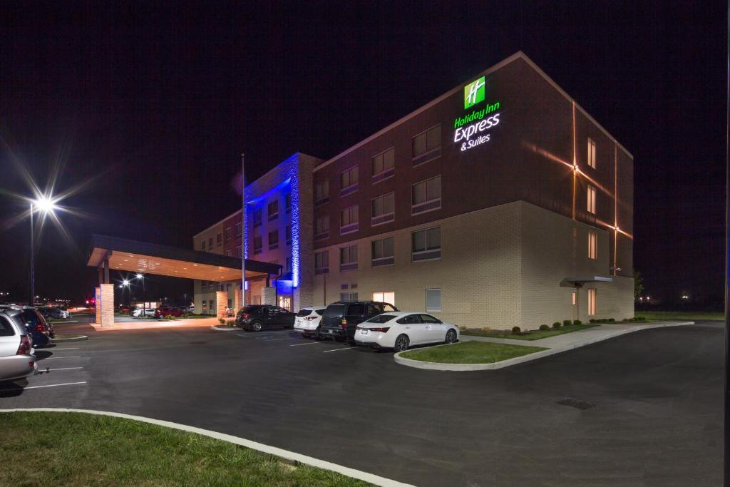 WhitestownHoliday Inn Express & Suites - Indianapolis NW - Zionsville, an IHG Hotel的夜间在停车场停车的酒店