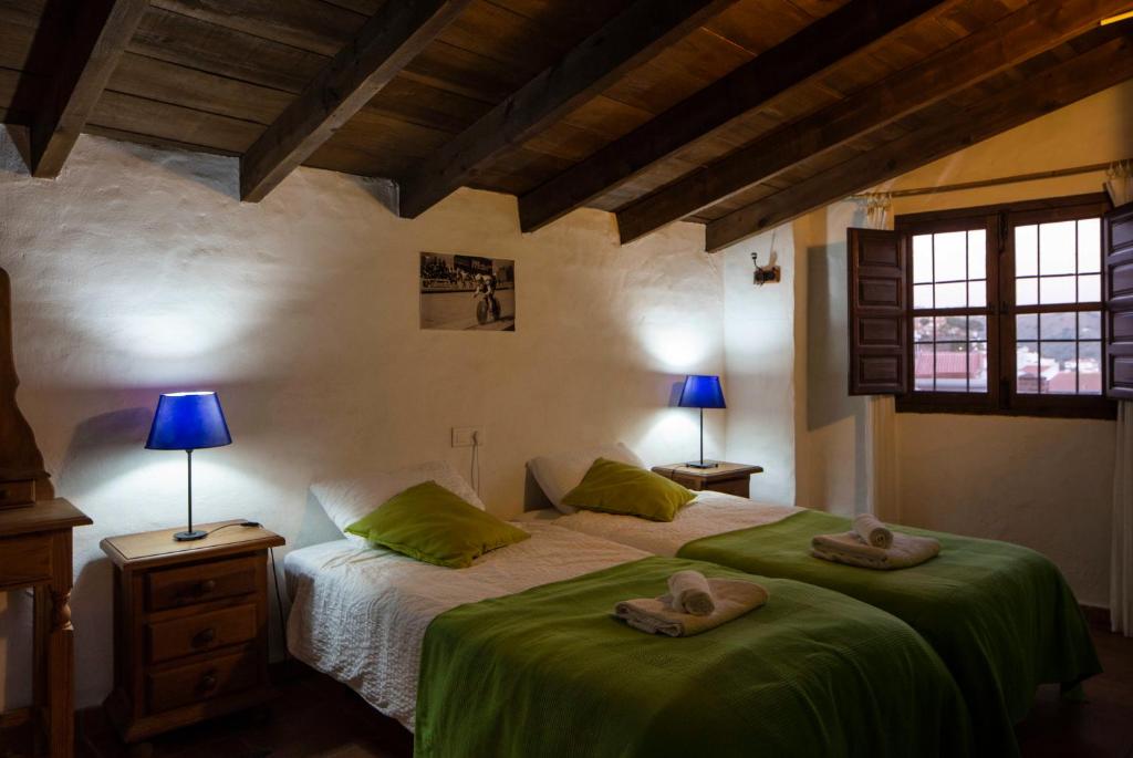 AlmácharCasa de Luz的一间卧室,配有一张带两顶帽子的床
