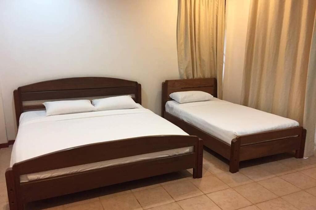 昆达桑Bonsai Villa @ Mesilou 盆栽小苑的配有衬衫的酒店客房内的两张床