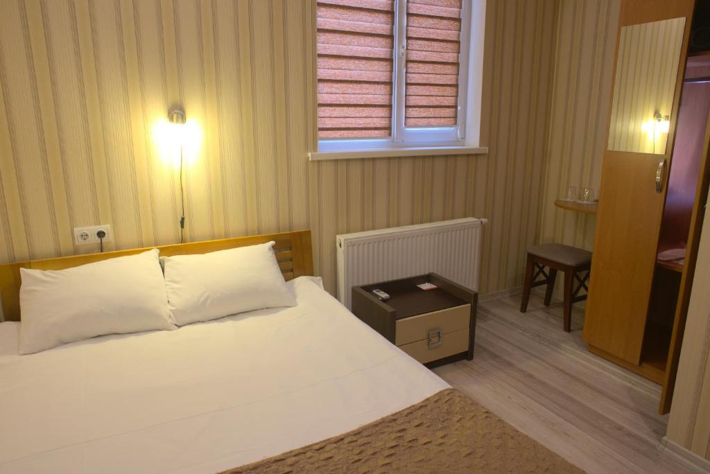 基辅The apartments的一间卧室配有一张床、一张桌子和一个窗户。