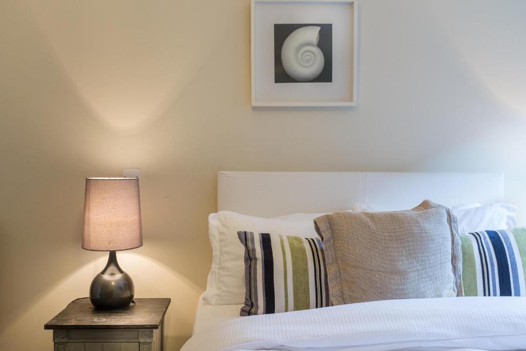 伦敦河滨公寓的一间卧室配有一张床和一张桌子上的台灯