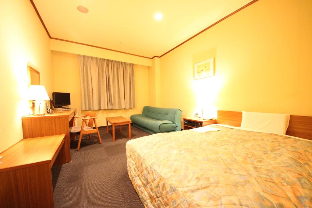 岐阜New Gifu Hotel Plaza的酒店客房配有一张床、一把椅子和一张书桌
