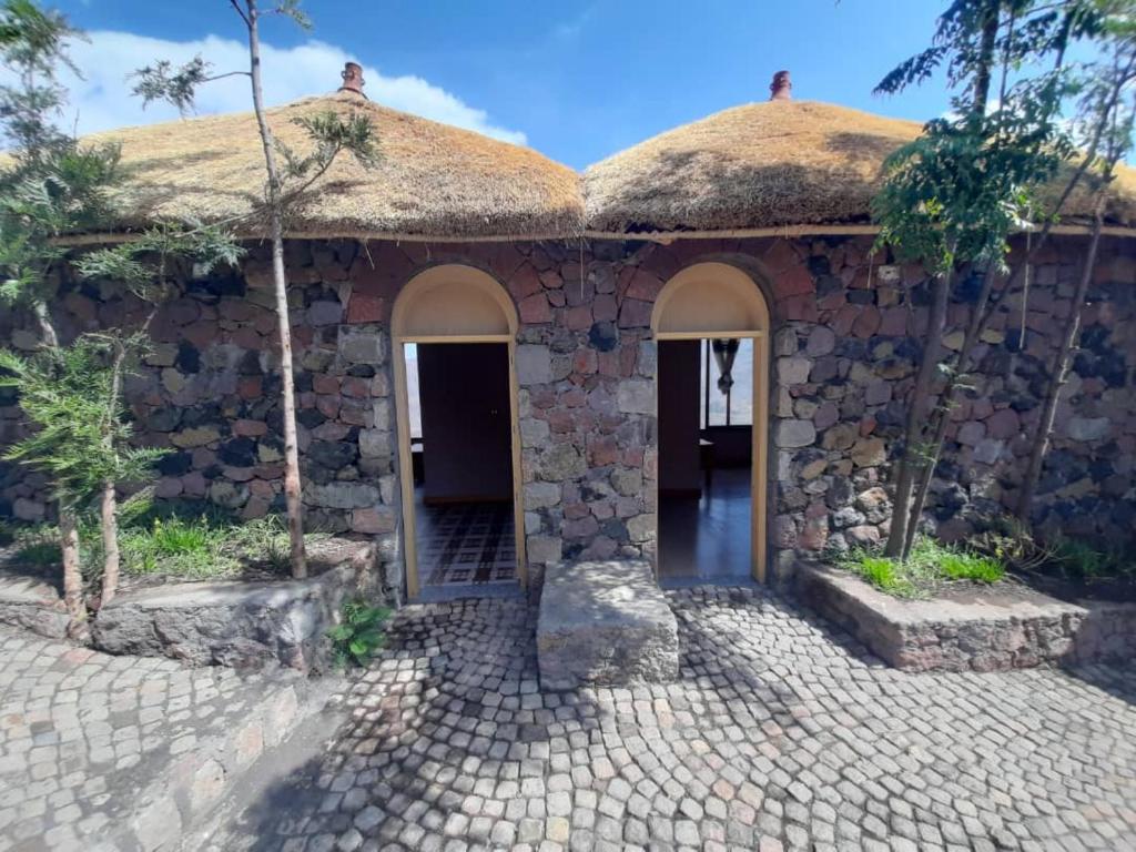拉利贝拉Ben Abeba Lodge & Tukul的茅草屋顶的石头房子