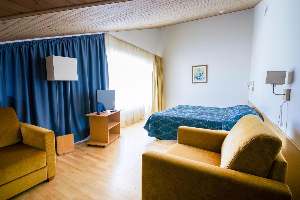 哈普萨卢弗拉马雷海水浴场Spa酒店的一间卧室配有一张床、一张沙发和一把椅子