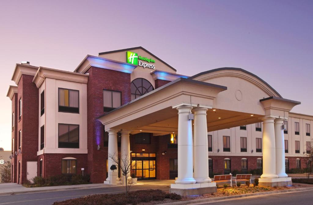 派恩布拉夫Holiday Inn Express & Suites Pine Bluff/Pines Mall, an IHG Hotel的一座酒店大楼,上面有标志