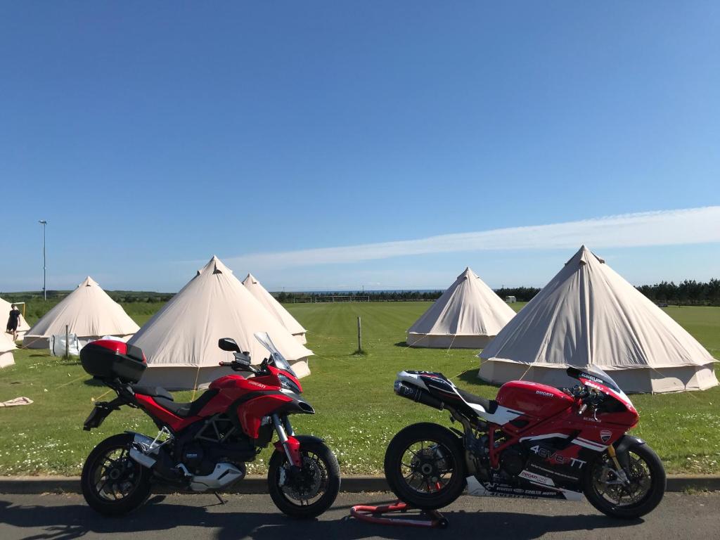 Colby4Ever TT Glamping的两辆摩托车停在一些帐篷前