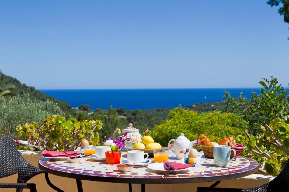 圣卡洛斯Agroturismo Can Talaias San CArlos的一张桌子,上面摆放着食物和饮料,享有海景