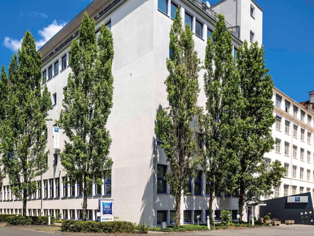 纽伦堡纽伦堡市博览会宜必思快捷酒店的前面有树木的白色建筑