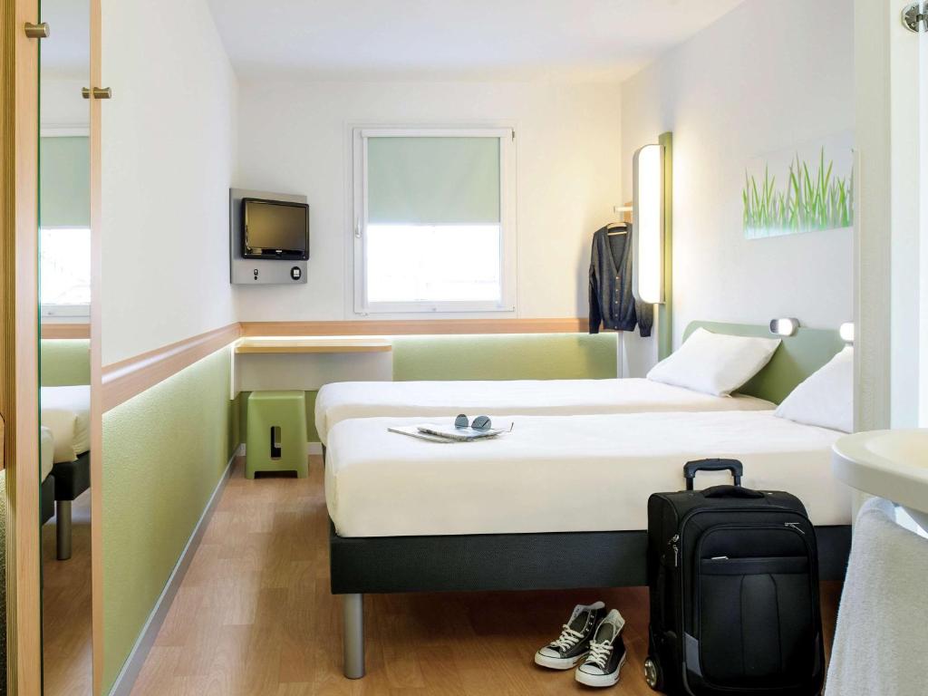 阿利坎特ibis budget Alicante的酒店客房,带一张床和行李箱