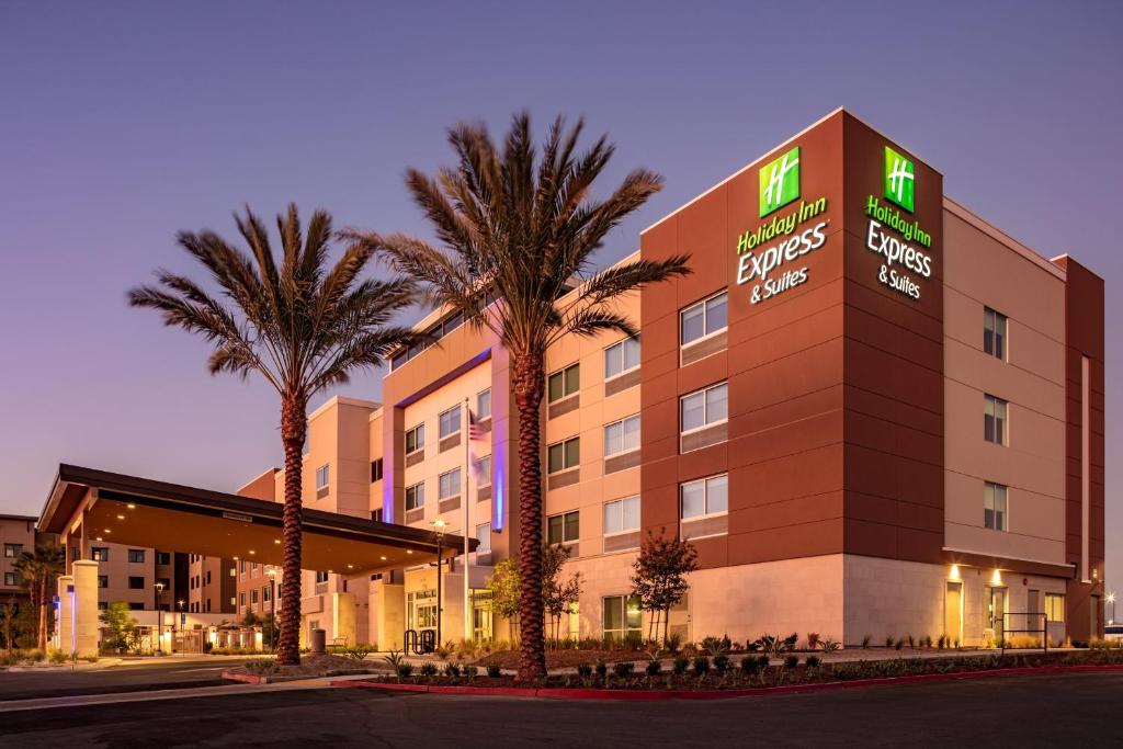 莫雷诺谷Holiday Inn Express & Suites - Moreno Valley - Riverside, an IHG Hotel的一座楼前有棕榈树的酒店