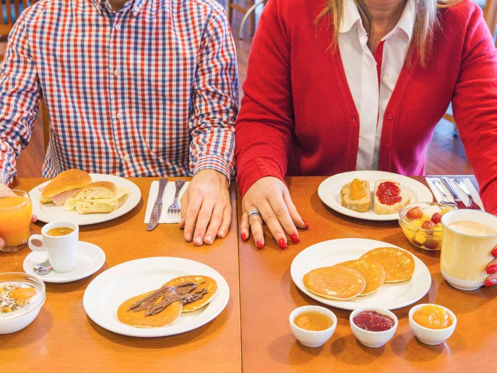 波尔图波尔图圣若昂宜必思酒店的两人坐在餐桌旁,边吃早餐