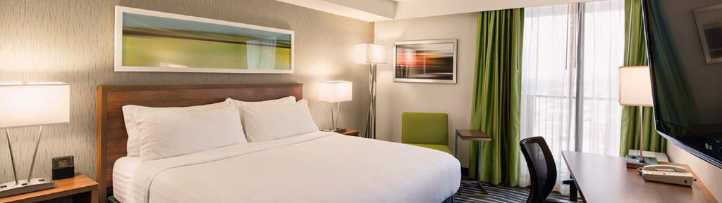 温尼伯机场西温尼伯假日酒店 的酒店客房设有一张床、一张书桌和窗户。
