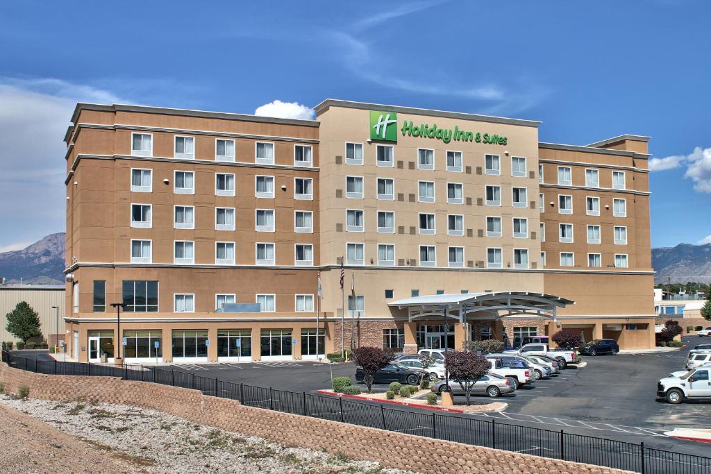 阿尔伯克基Holiday Inn & Suites Albuquerque-North I-25, an IHG Hotel的停车场内有车辆的旅馆