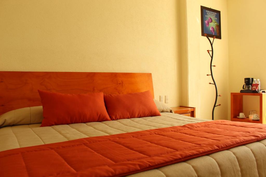 底拉斯卡拉塞尼奥丽拉特拉斯卡拉酒店的一间卧室配有一张带橙色枕头的大床