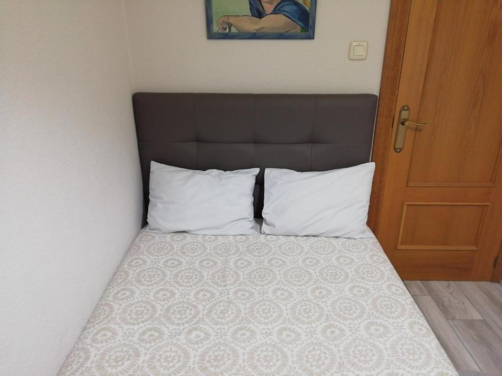 萨莫拉Monsalve10的一张带白色枕头和棕色床头板的床