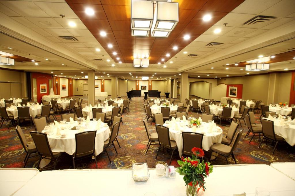德卢斯德卢斯市中心假日套房酒店的宴会厅配有白色的桌椅