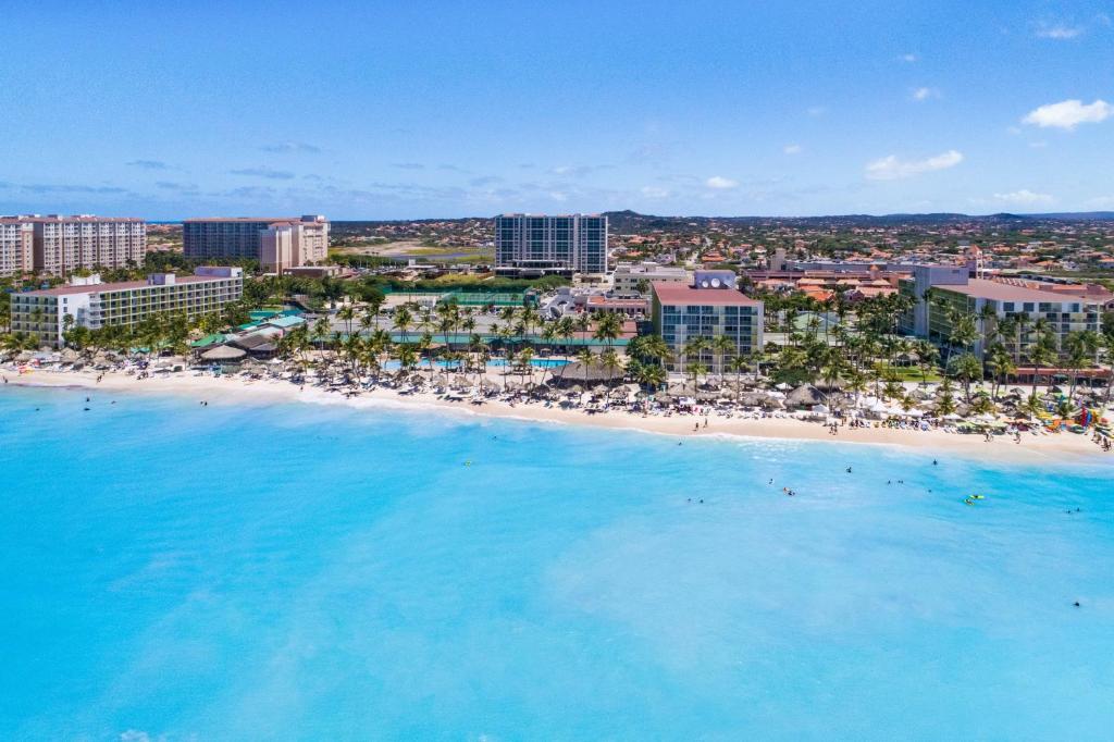 棕榈滩阿鲁巴假日酒店 - 海滩度假村及赌场的享有海滩的空中景致,配有椅子和遮阳伞