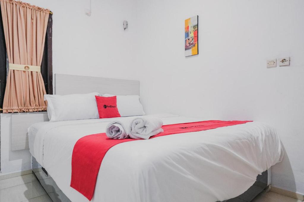 明古鲁省RedDoorz near Jalan Soeprapto Bengkulu的卧室配有白色床和毛巾