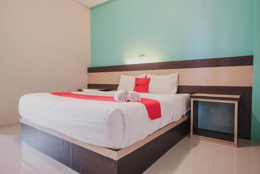 明古鲁省RedDoorz Syariah at Hotel Grand Mentari的一间卧室配有一张大床和两条毛巾