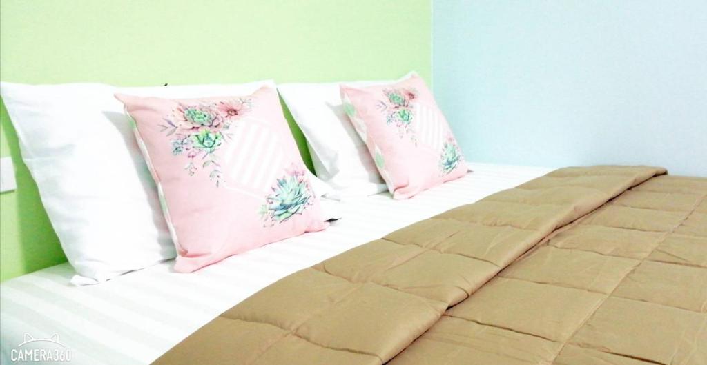 甲米镇Khao Thong Home Stay的床上配有粉色和白色枕头的床