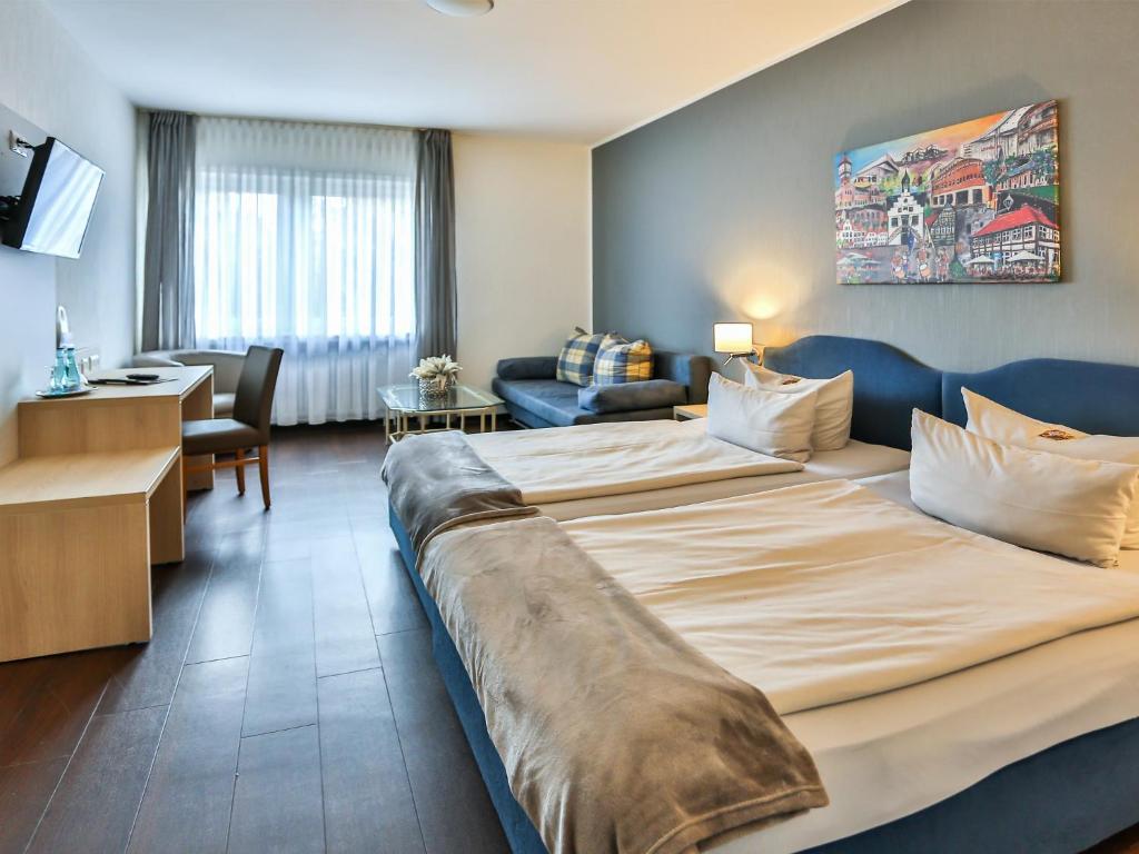 林根科尔平豪斯酒店-餐厅的酒店客房设有一张大床和一间客厅。