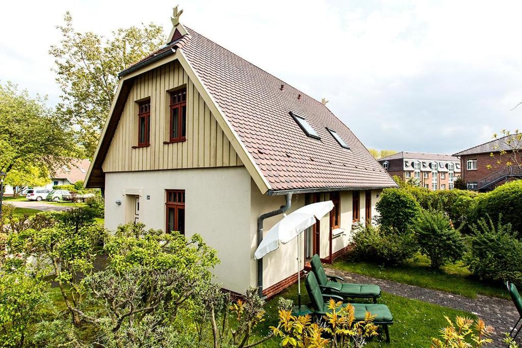 欧巴德伍斯图Ferienhaussiedlung Strandperlen Weidenhof 2a (Typ III)的一间白色的小房子,有 ⁇ 帽屋顶