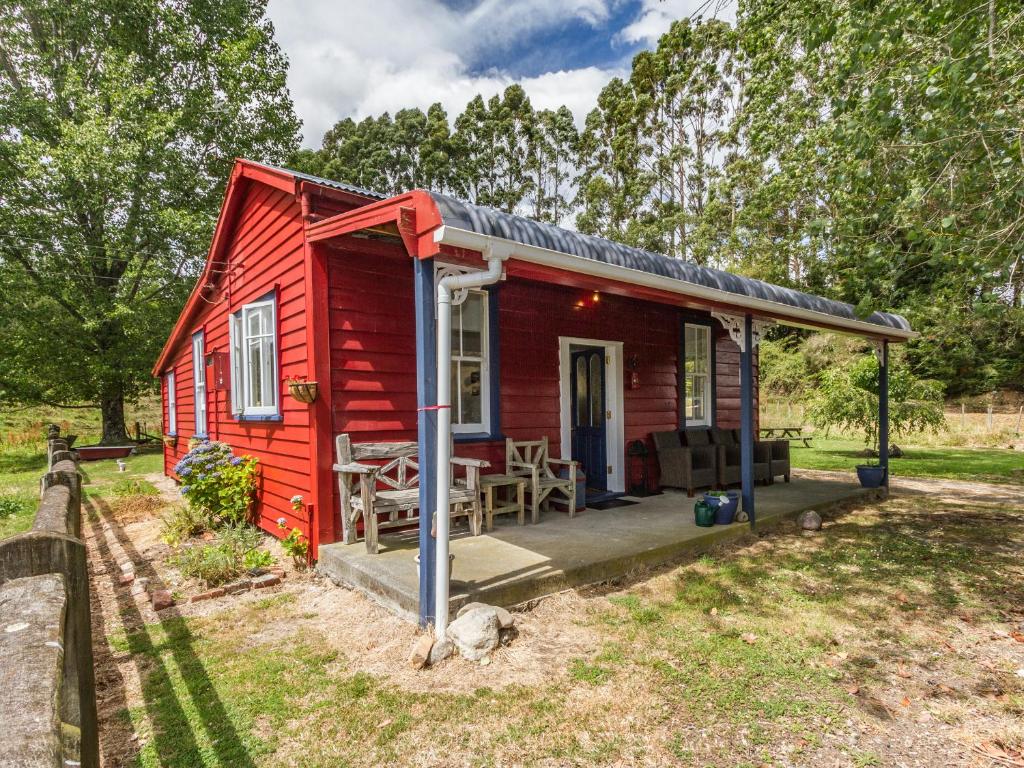 Raurimu SpiralThe Red Rooster Cottage的红色的小房子,带门廊