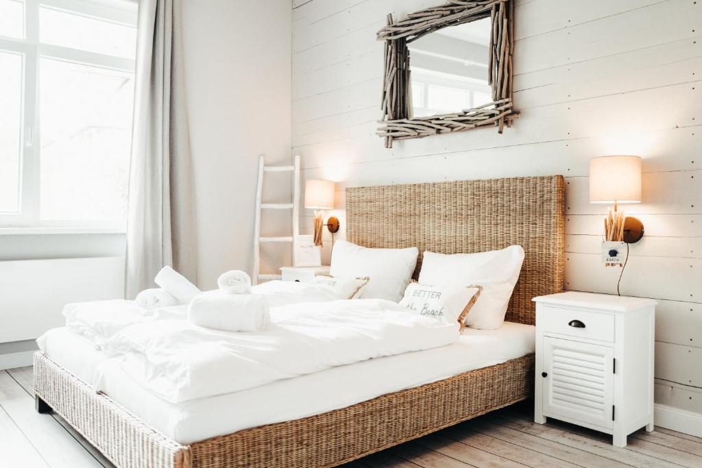 蒂门多弗施特兰德BeachBude Apartments的卧室配有一张白色大床和镜子