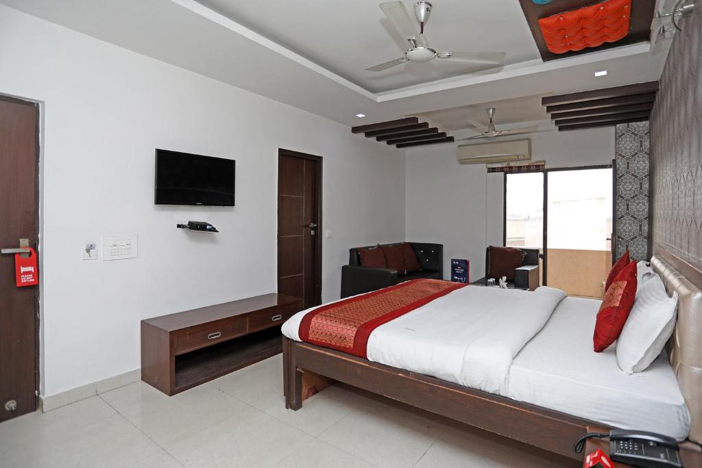 古尔冈Hotel Flora Inn的卧室配有一张床,墙上配有电视。
