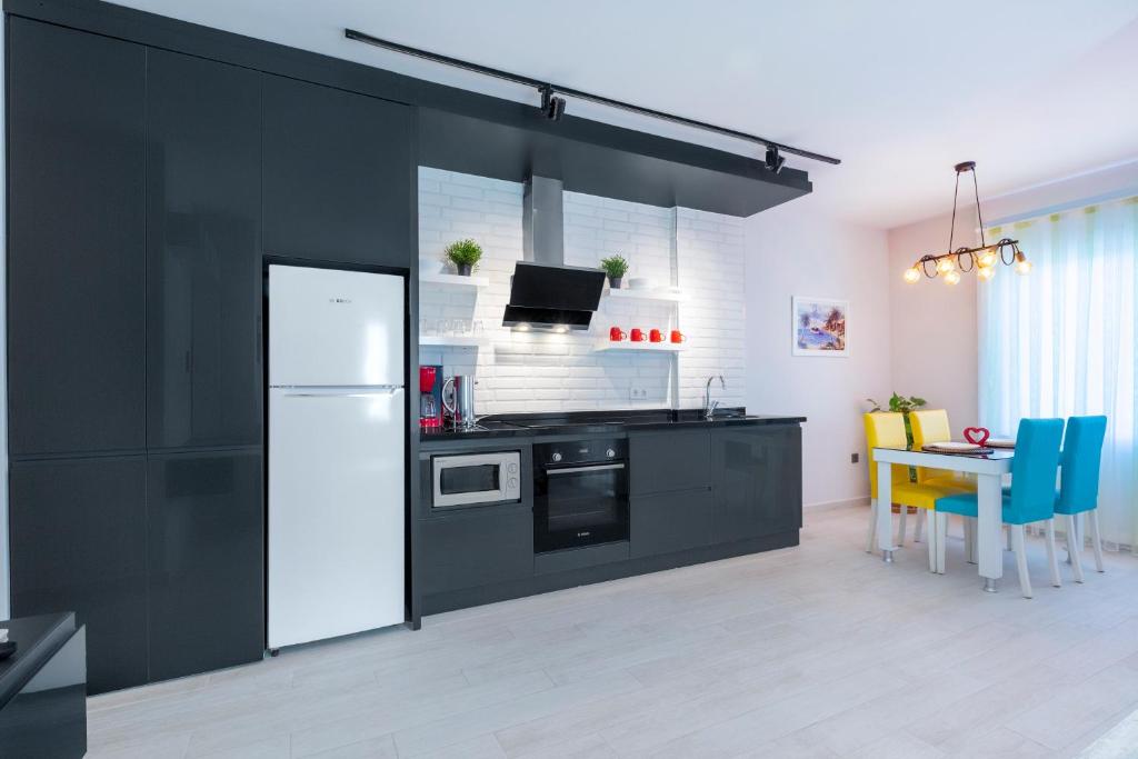 阿拉尼亚特纹公寓酒店的厨房配有黑色橱柜和白色冰箱。