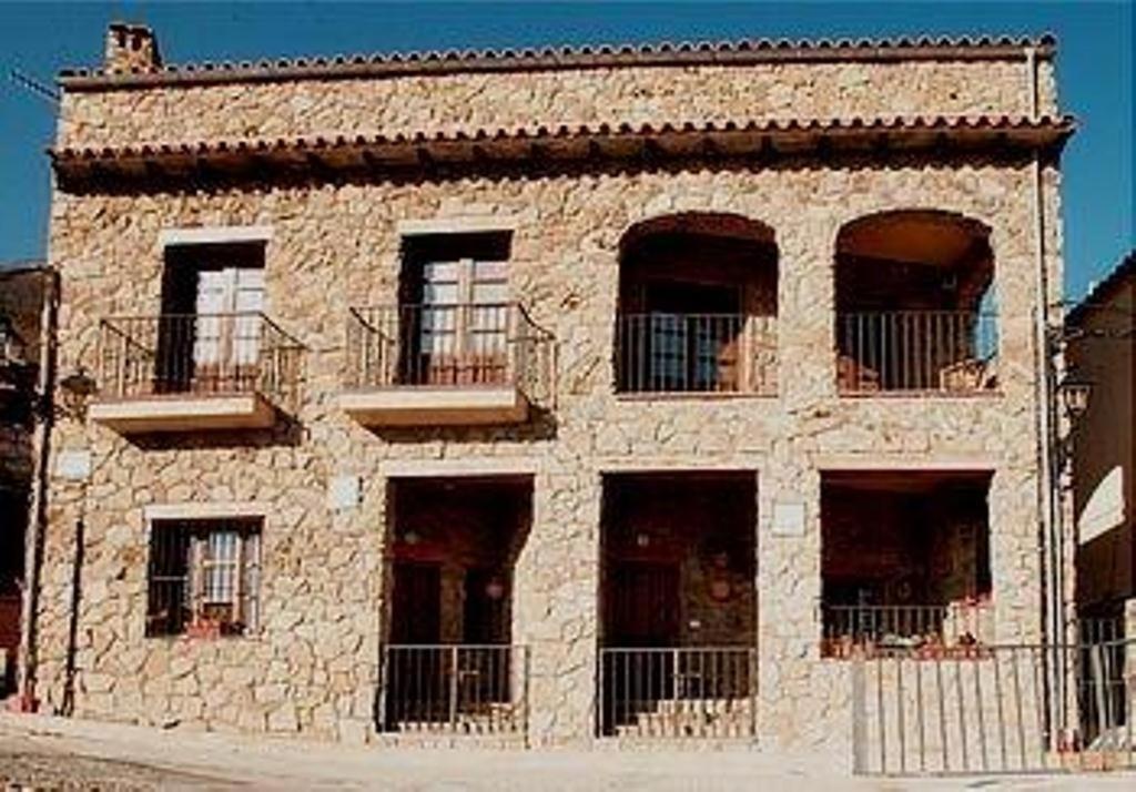 RebollarCasa Rural Las Gamellas的一座大型石头建筑,设有窗户和阳台