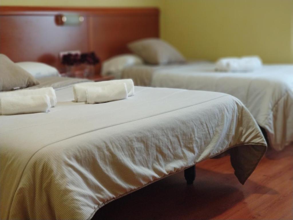 布尔戈斯Hostal Restaurante Iruñako的两张带白色床单和枕头的床。